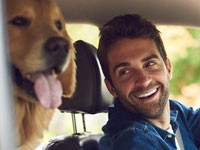 Man traveling with his dog in a car